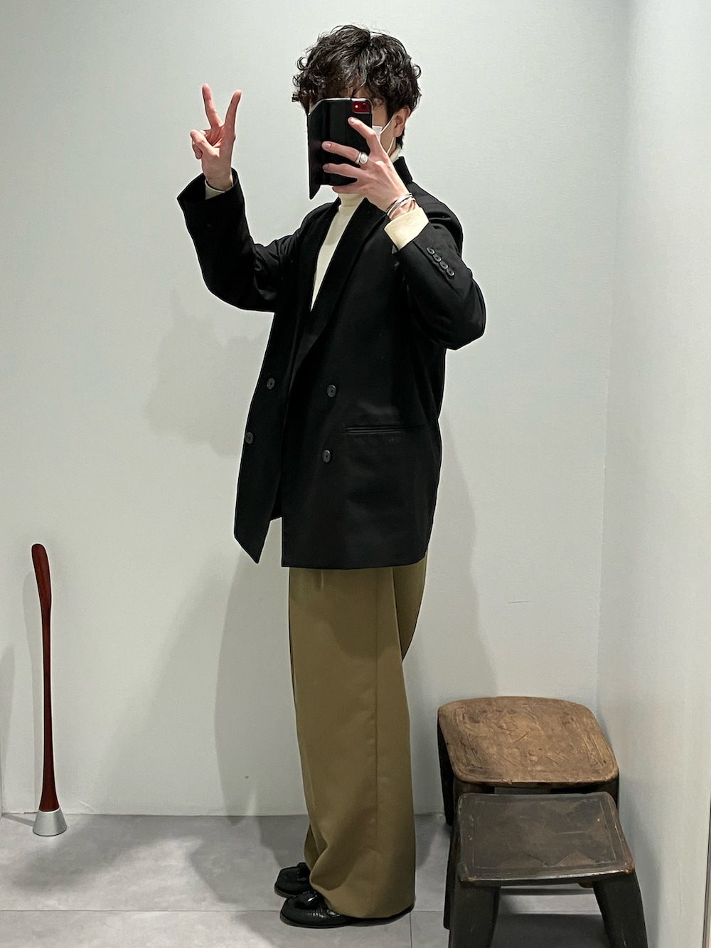 ホワイト系のニット/セーター、ブラック系のスーツジャケット、グリーン系のパンツを着用したメンズの冬コーディネートの3枚目の写真