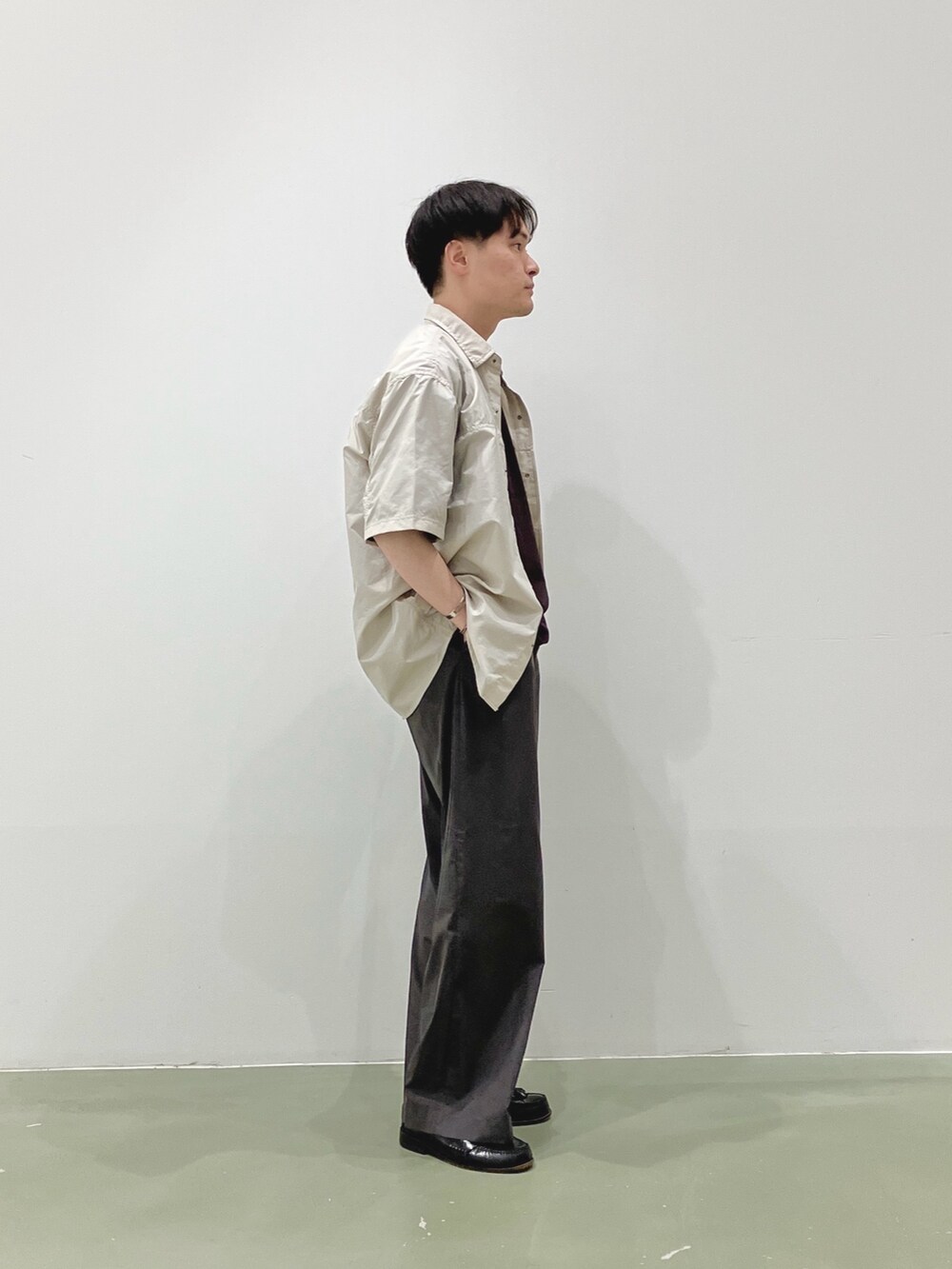 ベージュ系のシャツ/ブラウス、ブラウン系のTシャツ/カットソー、グレー系のスラックスを着用したメンズの夏コーディネートの2枚目の写真