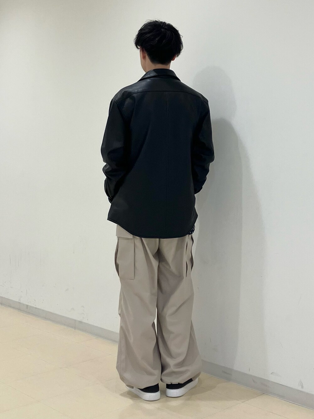 ブラック系のブルゾン、ブルー系のシャツ/ブラウス、ベージュ系のカーゴパンツを着用したメンズの春コーディネートの3枚目の写真