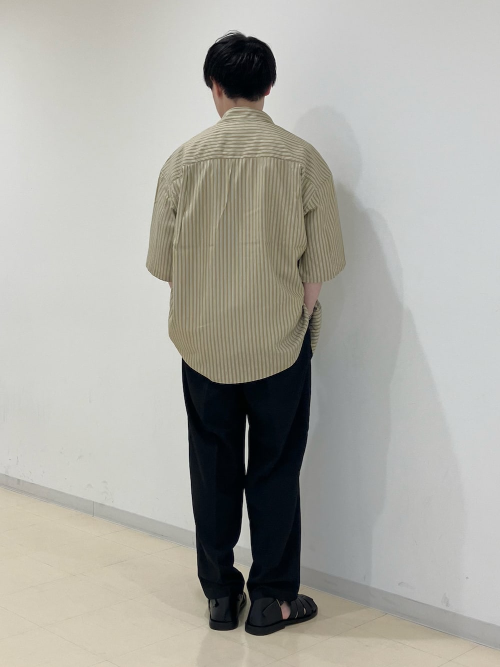 ベージュ系のシャツ/ブラウス、イエロー系のTシャツ/カットソー、ブラック系のスラックスを着用したメンズの春コーディネートの3枚目の写真