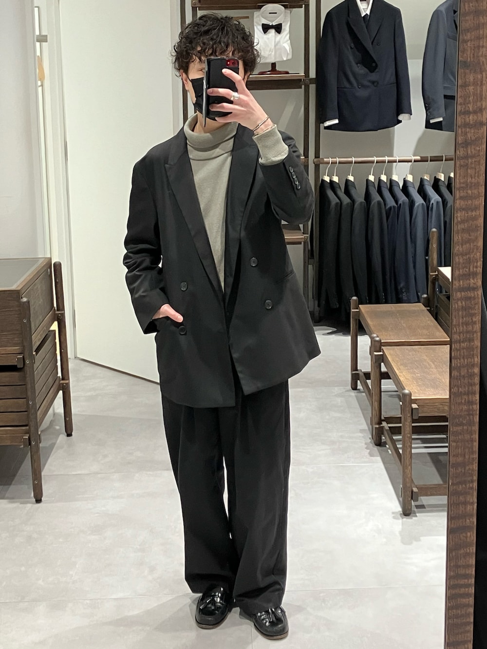 ブラック系のスーツジャケット、ブラック系のパンツ、ブラック系のローファーを着用したメンズの冬コーディネートの3枚目の写真