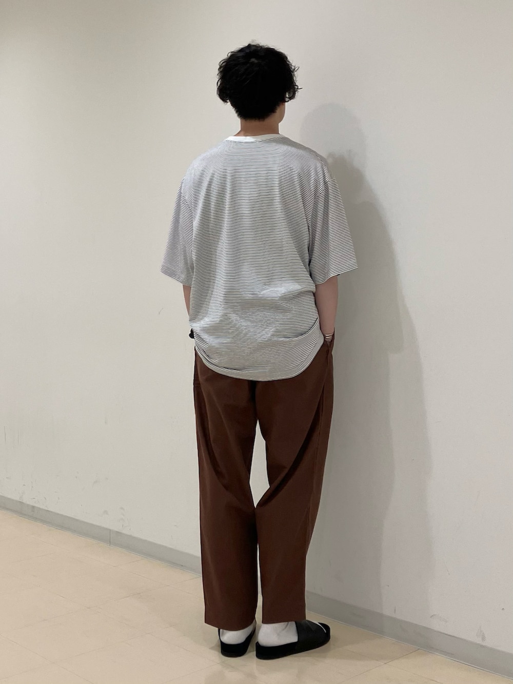 ホワイト系のTシャツ/カットソー、ブラウン系のその他パンツ、ブラック系のサンダルを着用したメンズの夏コーディネートの3枚目の写真