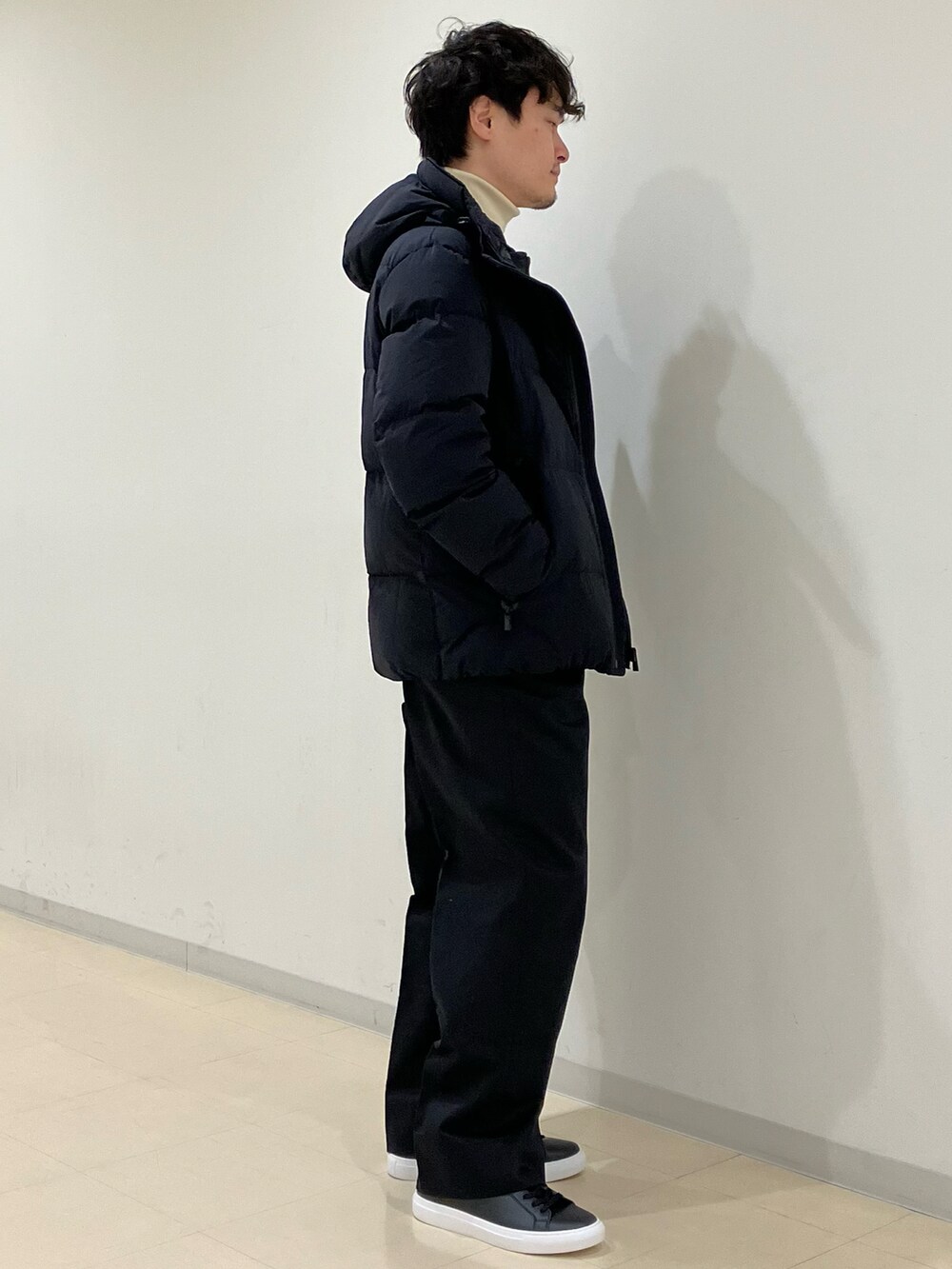 ホワイト系のニット/セーター、ブラック系のダウンジャケット/コート、ブラック系のその他パンツを着用したメンズの冬コーディネートの2枚目の写真