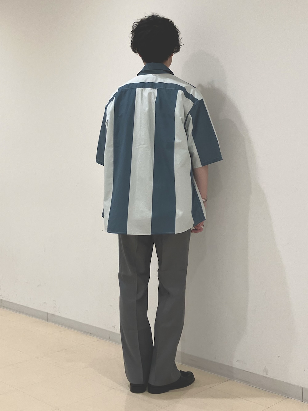 グレー系のシャツ/ブラウス、ホワイト系のTシャツ/カットソー、グレー系のスラックスを着用したメンズの夏コーディネートの3枚目の写真