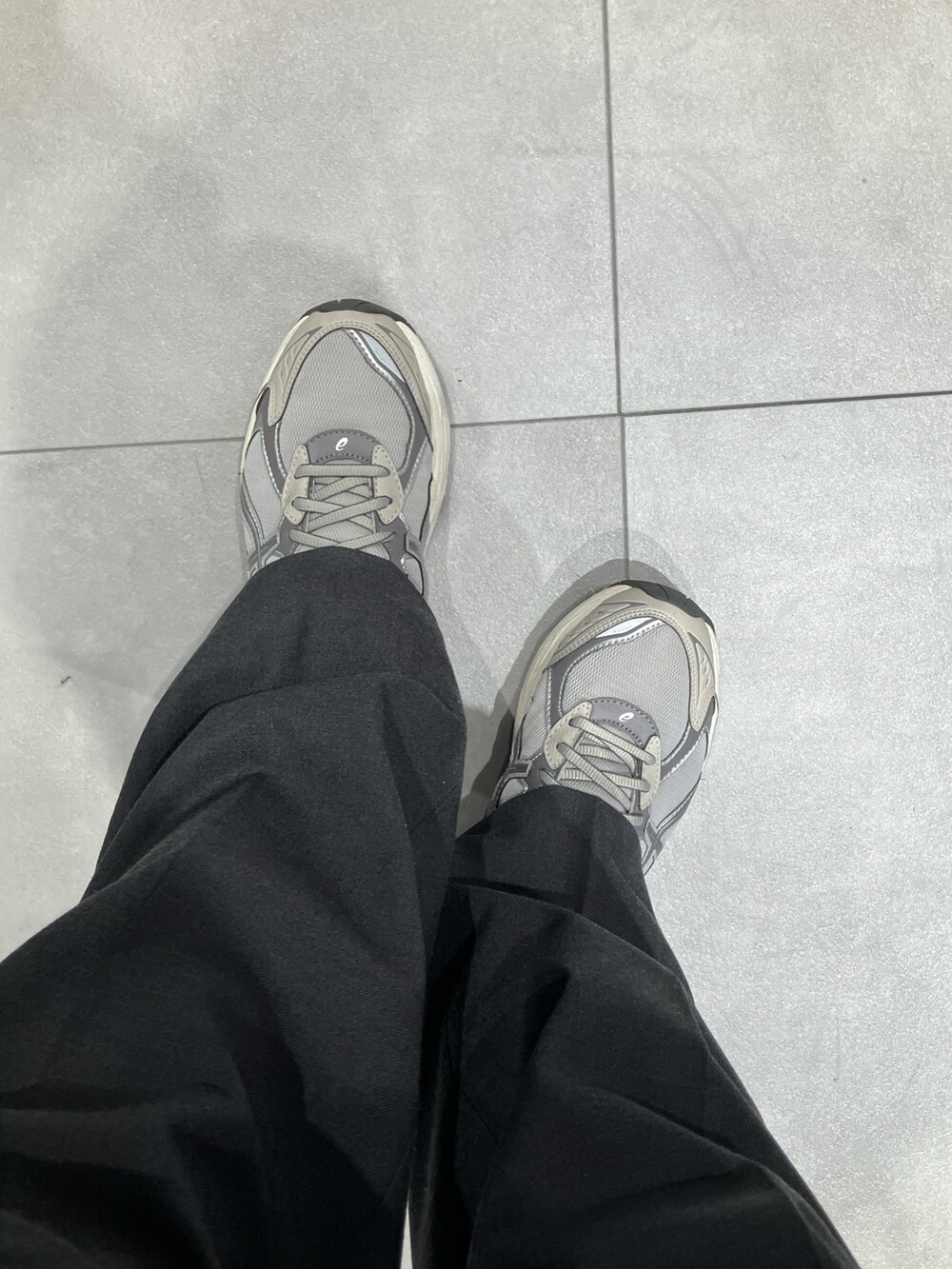 グリーン系のミリタリージャケット、ブラウン系のニット/セーター、グレー系のスラックスを着用したメンズの冬コーディネートの3枚目の写真