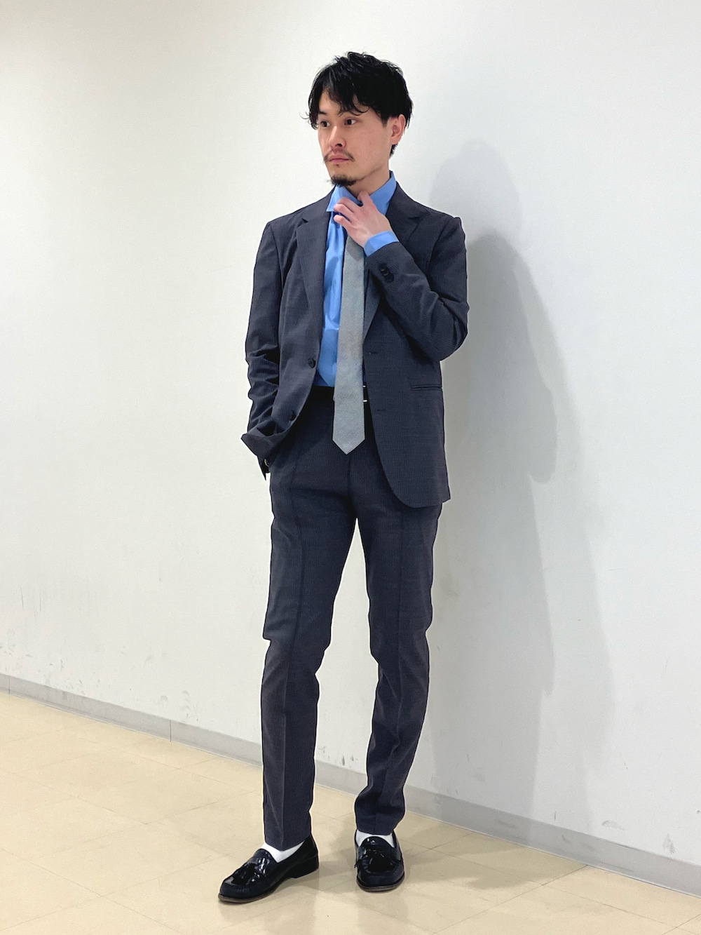 グレー系のスーツジャケット、グレー系のスラックス、ブルー系のシャツ/ブラウスを着用したメンズの春コーディネートの2枚目の写真