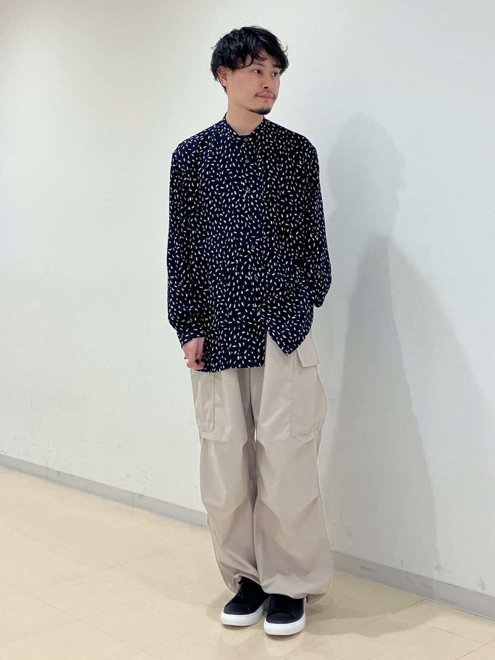 ブラック系のブルゾン、ブルー系のシャツ/ブラウス、ベージュ系のカーゴパンツを着用したメンズの春コーディネートの4枚目の写真