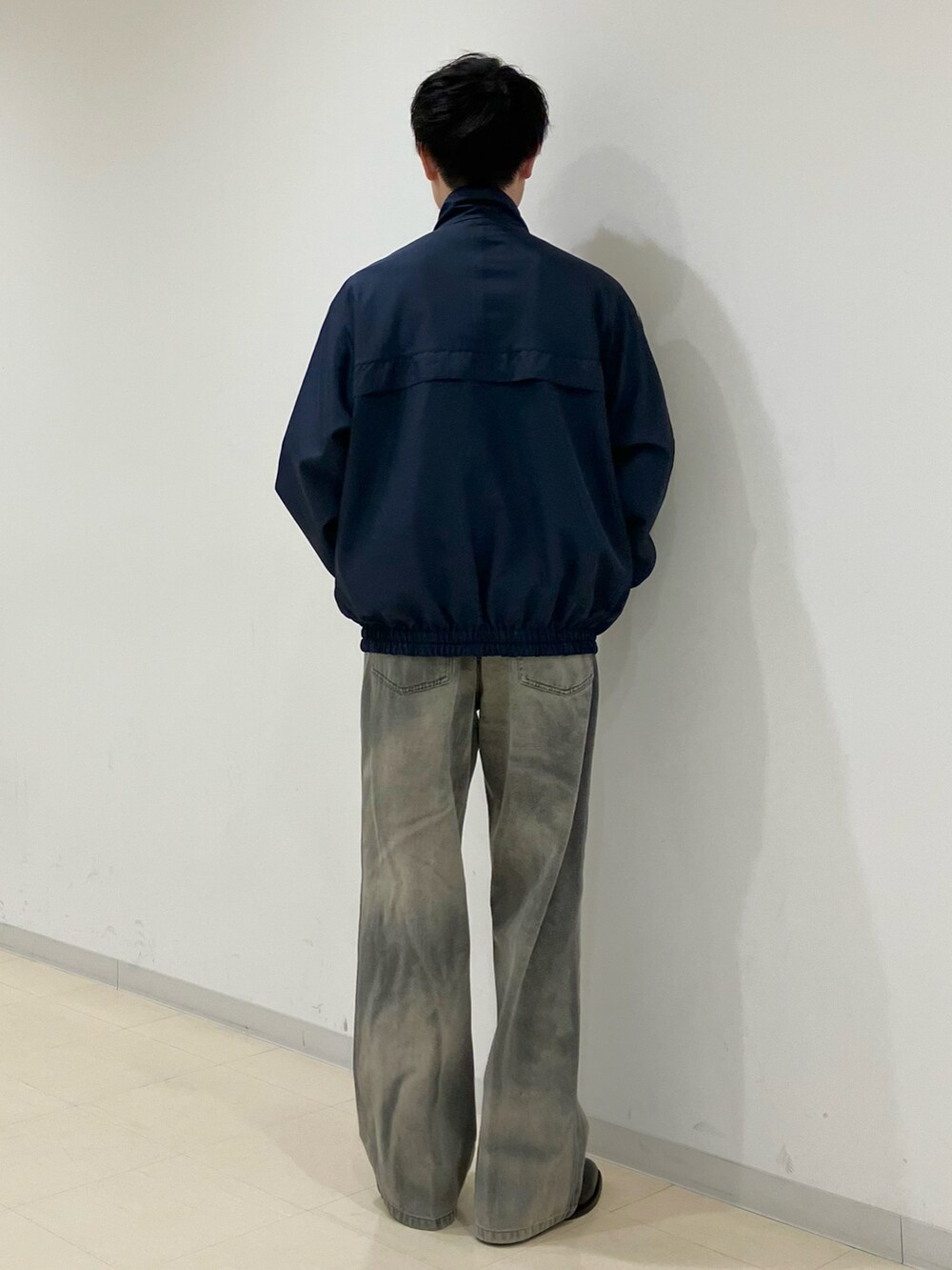 ブルー系のブルゾン、ブラック系のデニムパンツ、ブラック系のブーツを着用したメンズの春コーディネートの3枚目の写真