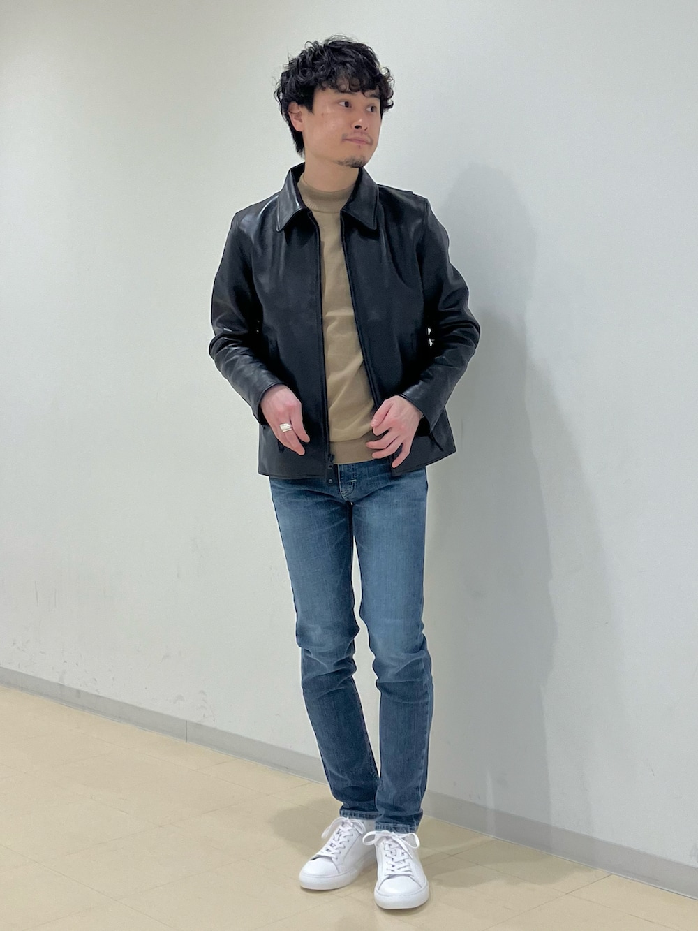 ブラウン系のチェスターコート、ブラック系のライダースジャケット、ブルー系のデニムパンツを着用したメンズの冬コーディネートの5枚目の写真