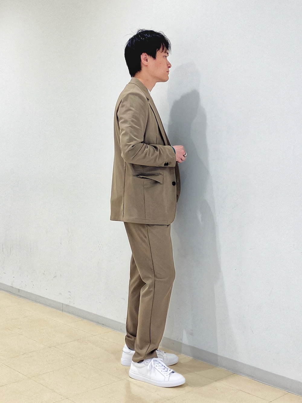 ベージュ系のセットアップ、グリーン系のニット/セーター、ホワイト系のTシャツ/カットソーを着用したメンズの秋コーディネートの2枚目の写真