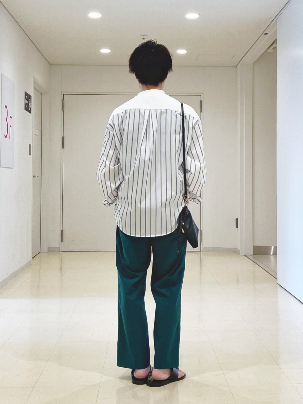 ホワイト系のTシャツ/カットソー、グリーン系のその他パンツ、ブラック系のサンダルを着用したメンズの春コーディネートの4枚目の写真