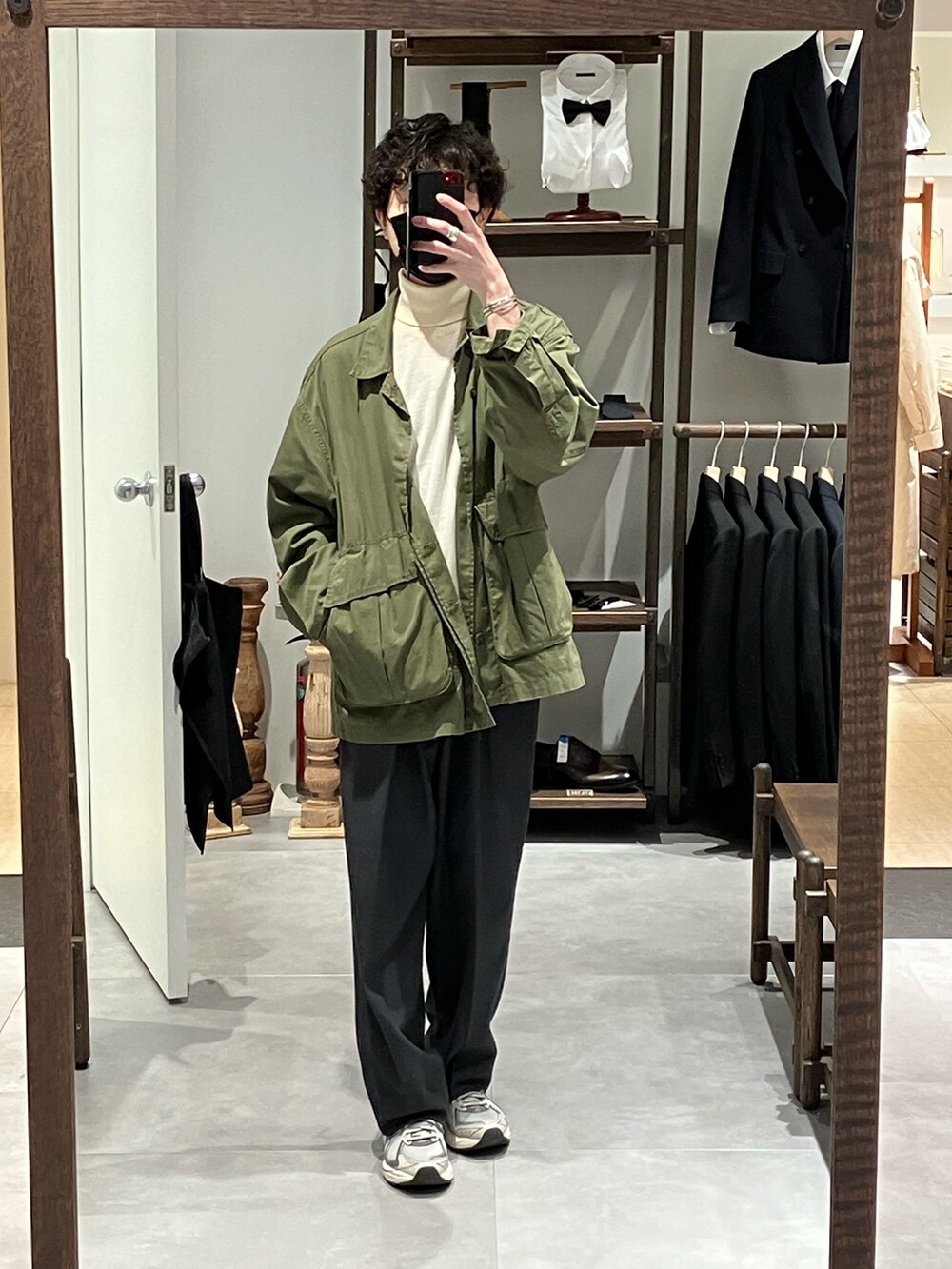 グリーン系のミリタリージャケット、ホワイト系のニット/セーター、グレー系のスラックスを着用したメンズの冬コーディネートの3枚目の写真