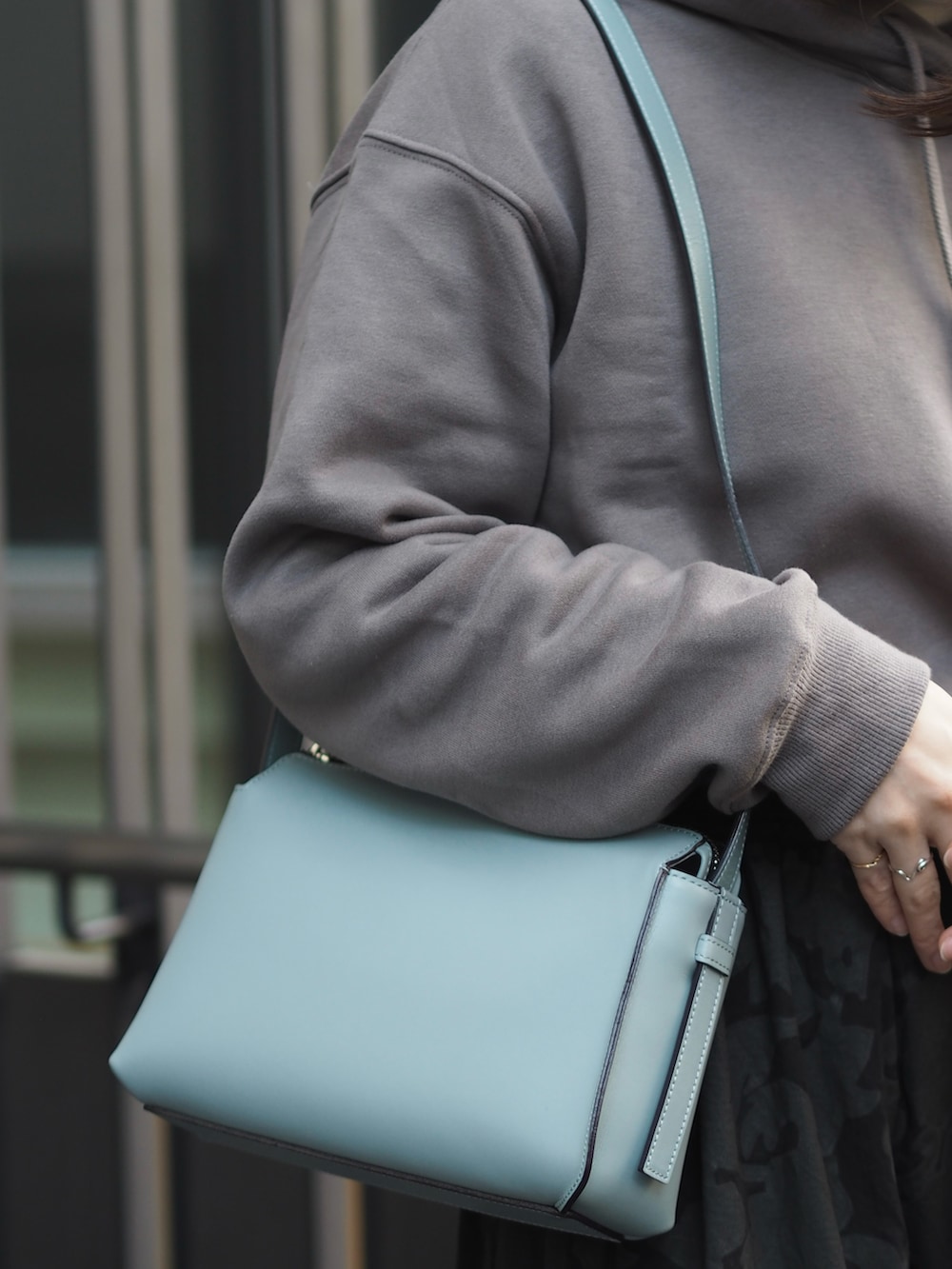 ブラック系のスカート、ブルー系のショルダーバッグ、グレー系のスウェットを着用したレディースの冬コーディネートの3枚目の写真