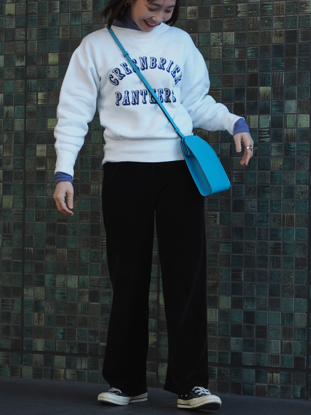 ブラック系のスニーカー、ブルー系のショルダーバッグ、ホワイト系のスウェットを着用したレディースの冬コーディネートの4枚目の写真