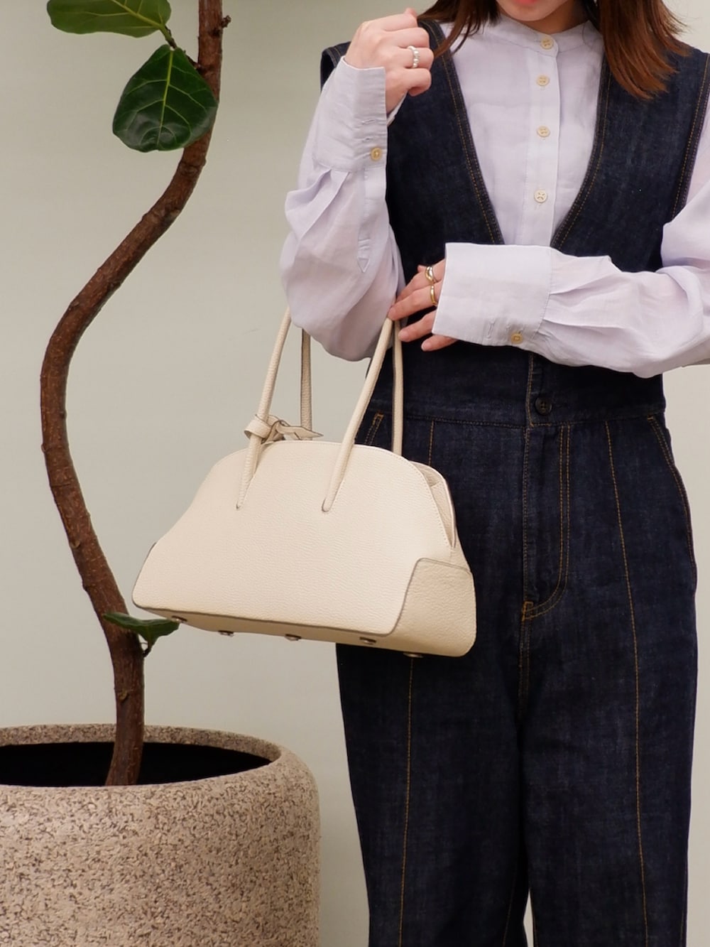 ベージュ系のボストンバッグ、ブルー系のサロペット/オーバーオール、ブルー系のシャツ/ブラウスを着用したレディースの春コーディネートの2枚目の写真