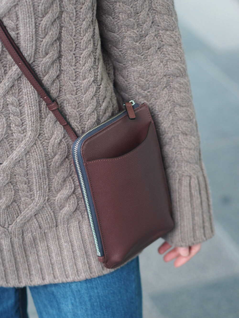 ブルー系のデニムパンツ、ブラック系のブーツ、ブラウン系のニット/セーターを着用したレディースの冬コーディネートの2枚目の写真