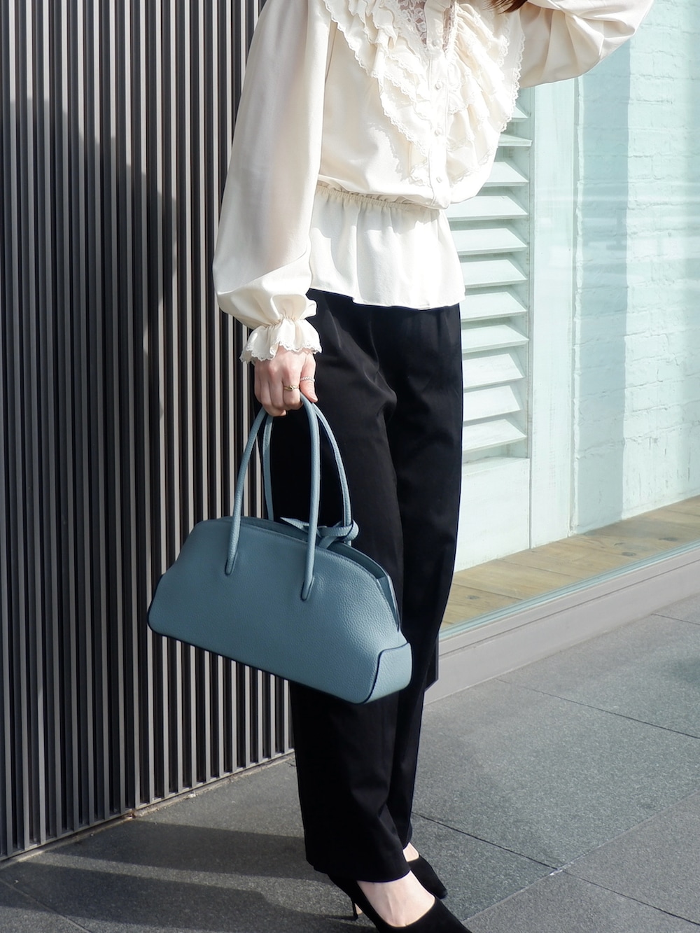 ブルー系のボストンバッグ、ブラック系のその他パンツ、ブラック系のパンプスを着用したレディースの春コーディネートの2枚目の写真