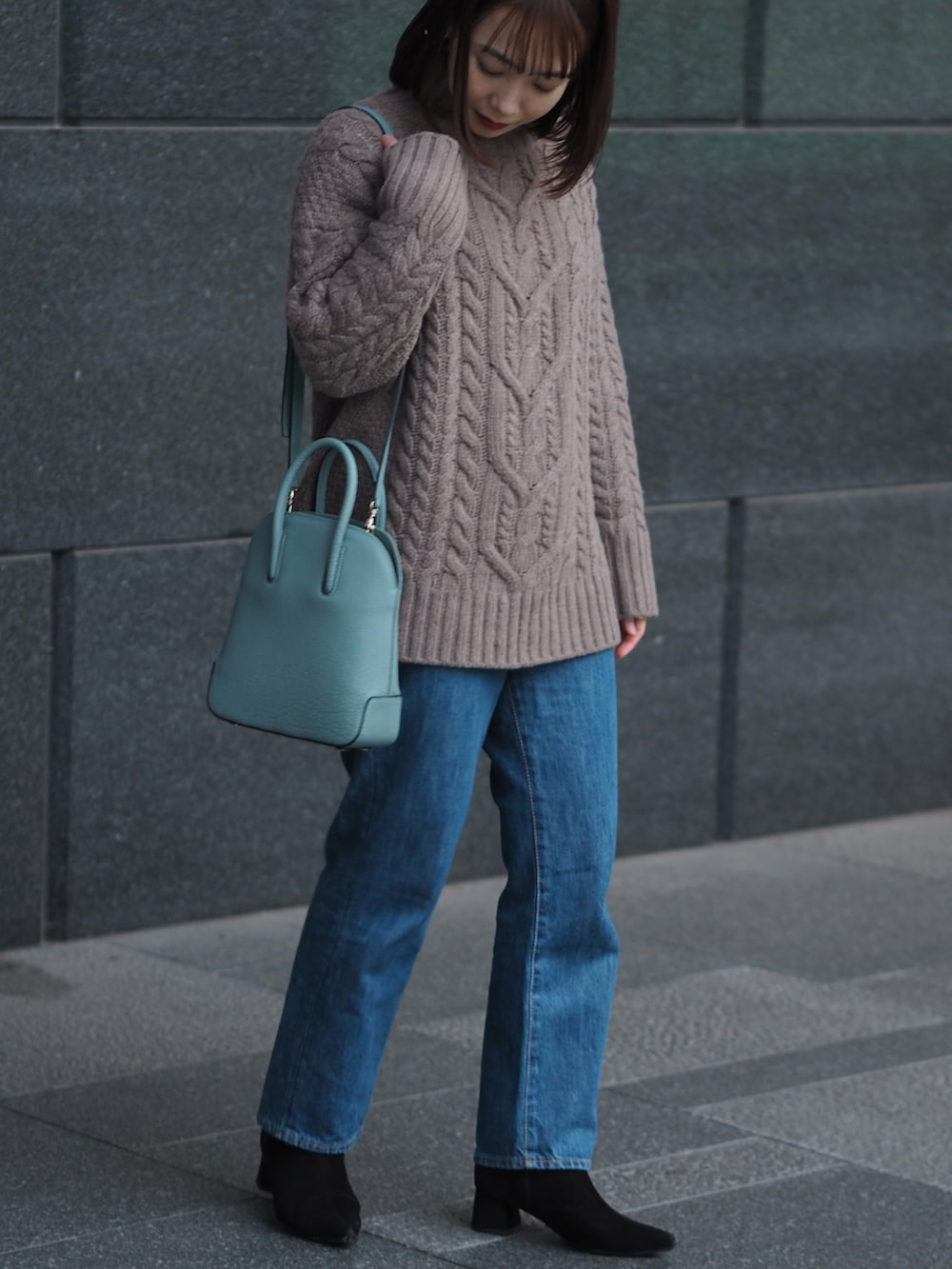 ブルー系のデニムパンツ、ブラック系のブーツ、ブラウン系のニット/セーターを着用したレディースの冬コーディネートの3枚目の写真