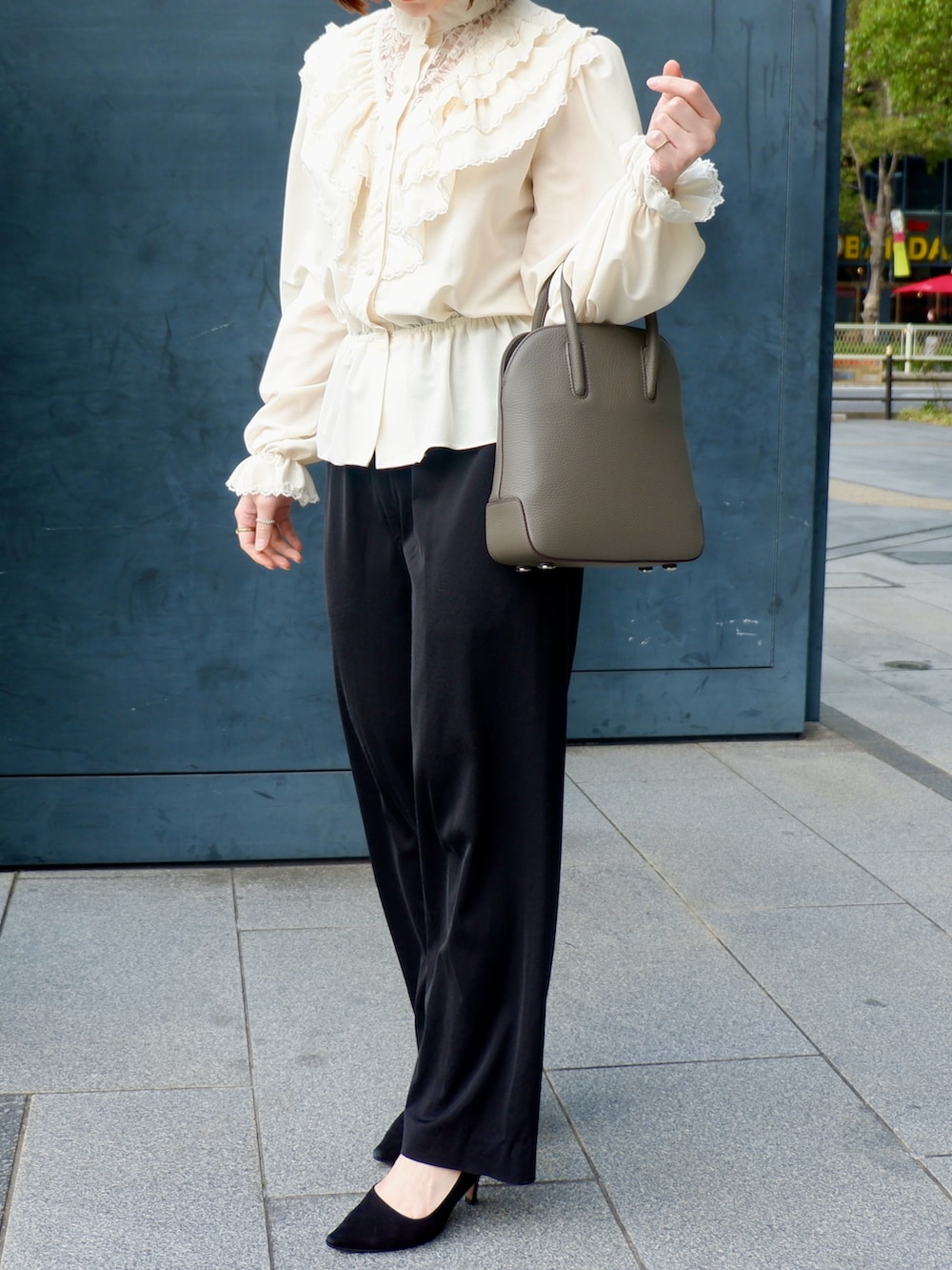 ブラウン系のショルダーバッグ、ブラック系のその他パンツ、ホワイト系のシャツ/ブラウスを着用したレディースの春コーディネートの2枚目の写真