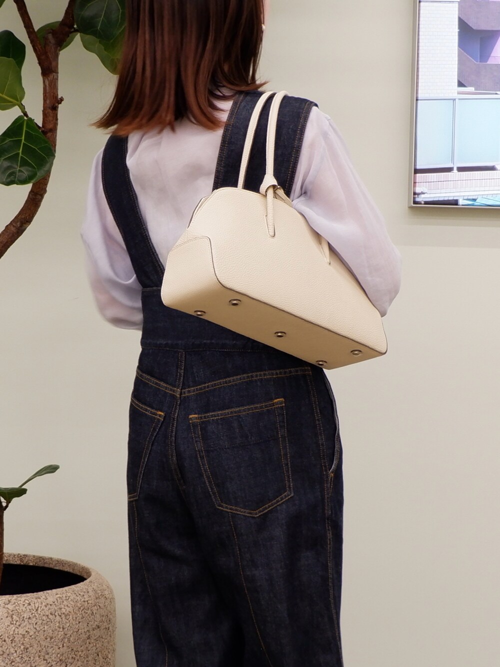 ベージュ系のボストンバッグ、ブルー系のサロペット/オーバーオール、ブルー系のシャツ/ブラウスを着用したレディースの春コーディネートの3枚目の写真