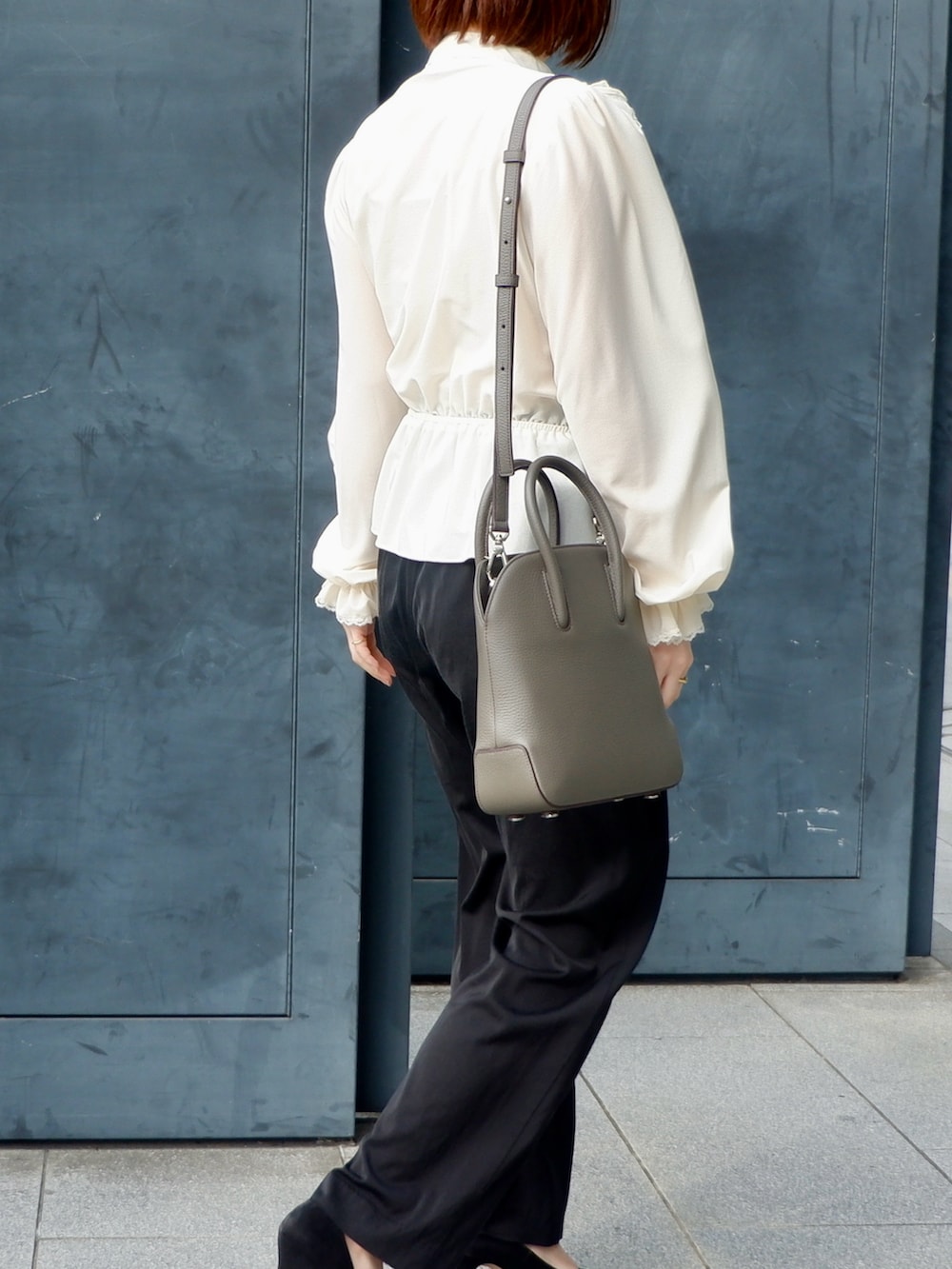 ブラウン系のショルダーバッグ、ブラック系のその他パンツ、ホワイト系のシャツ/ブラウスを着用したレディースの春コーディネートの3枚目の写真