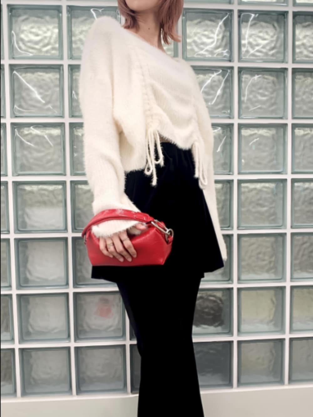 ブラック系のその他パンツ、レッド系のポーチを着用したレディースの秋コーディネートの3枚目の写真