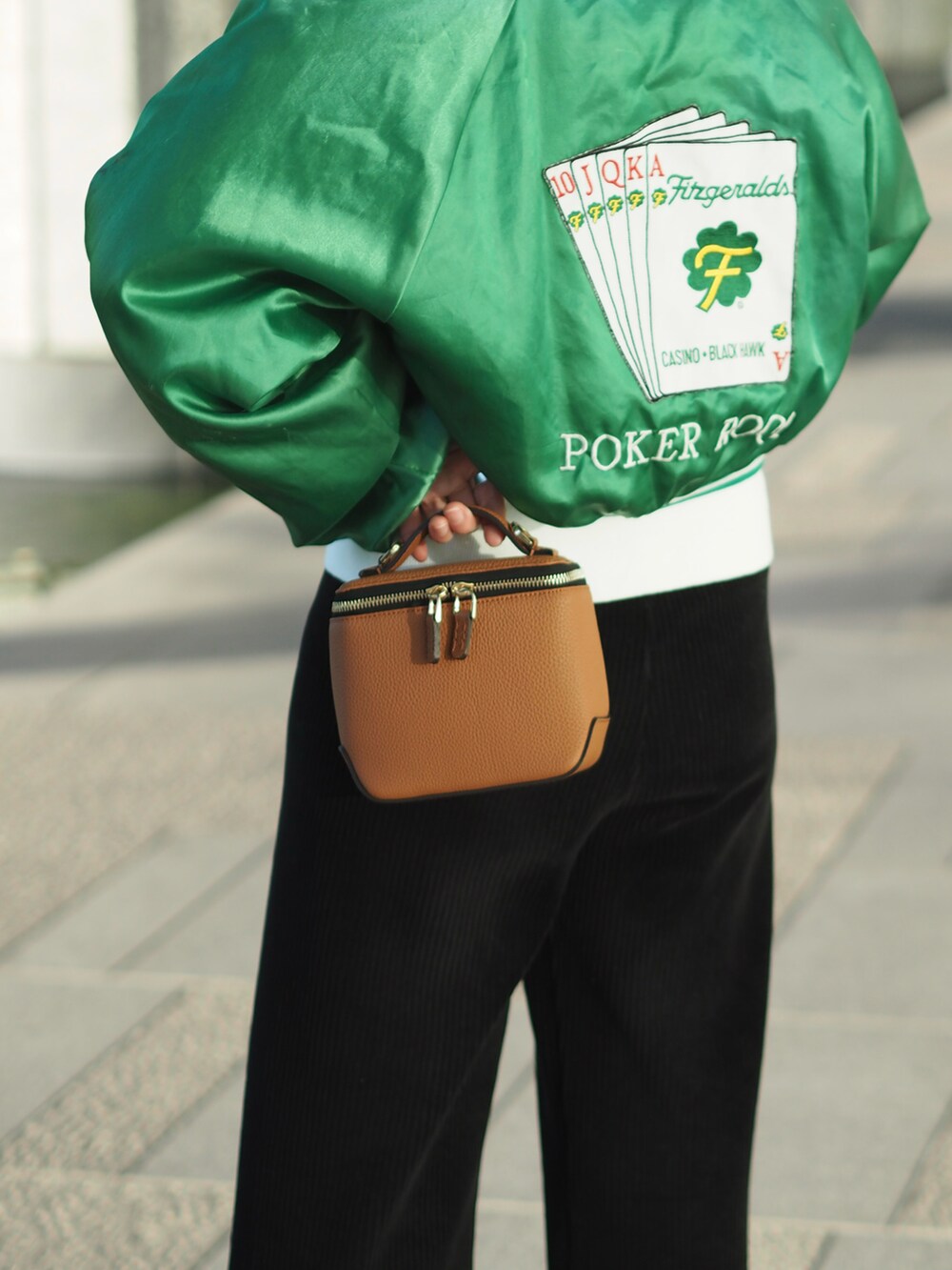 ブラック系のスニーカー、ブラウン系のショルダーバッグ、グリーン系のMA-1を着用したレディースの冬コーディネートの2枚目の写真