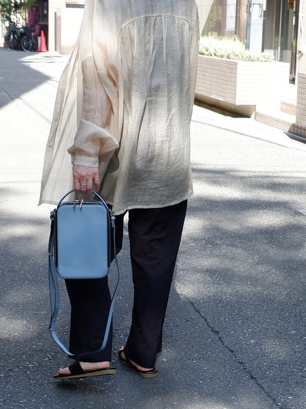 ブルー系のショルダーバッグ、ブラック系のその他パンツ、ブラック系のサンダルを着用したレディースの夏コーディネートの4枚目の写真