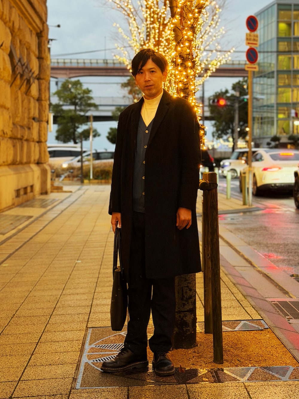 ブラック系のチェスターコート、ブルー系のカーディガン/ボレロ、ホワイト系のニット/セーターを着用したメンズの冬コーディネートの4枚目の写真