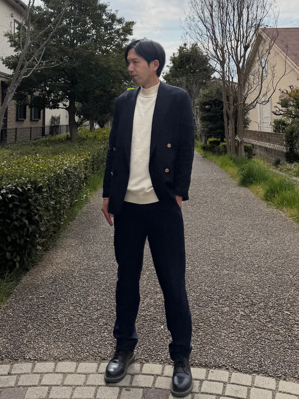 ブルー系のテーラードジャケット、ホワイト系のニット/セーター、ブルー系のスラックスを着用したメンズの春コーディネートの2枚目の写真