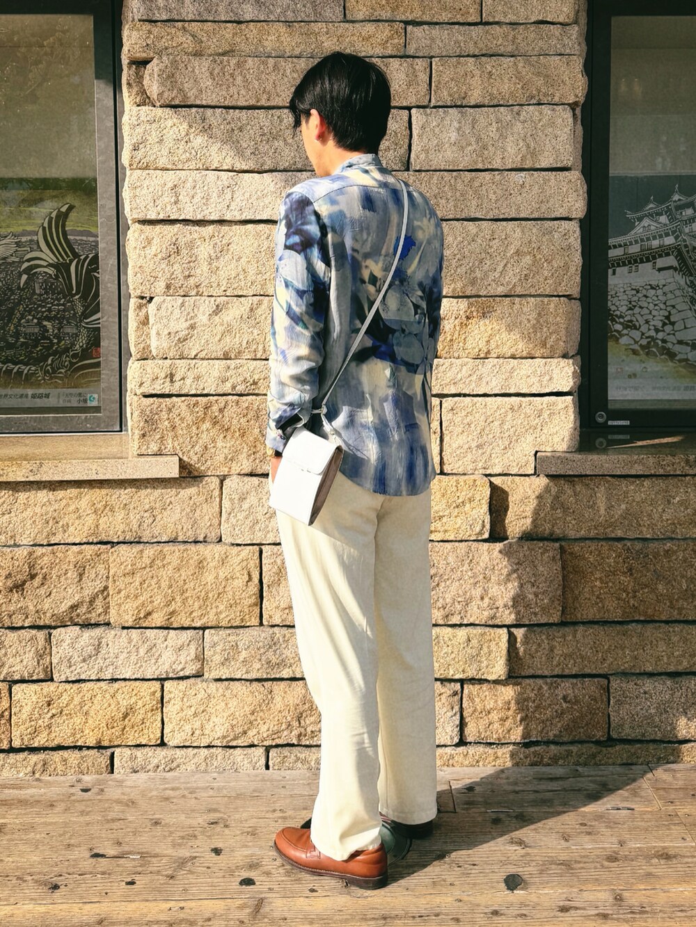 ブルー系のシャツ/ブラウス、ホワイト系のスラックス、シルバー系のイヤリングを着用したメンズの春コーディネートの2枚目の写真