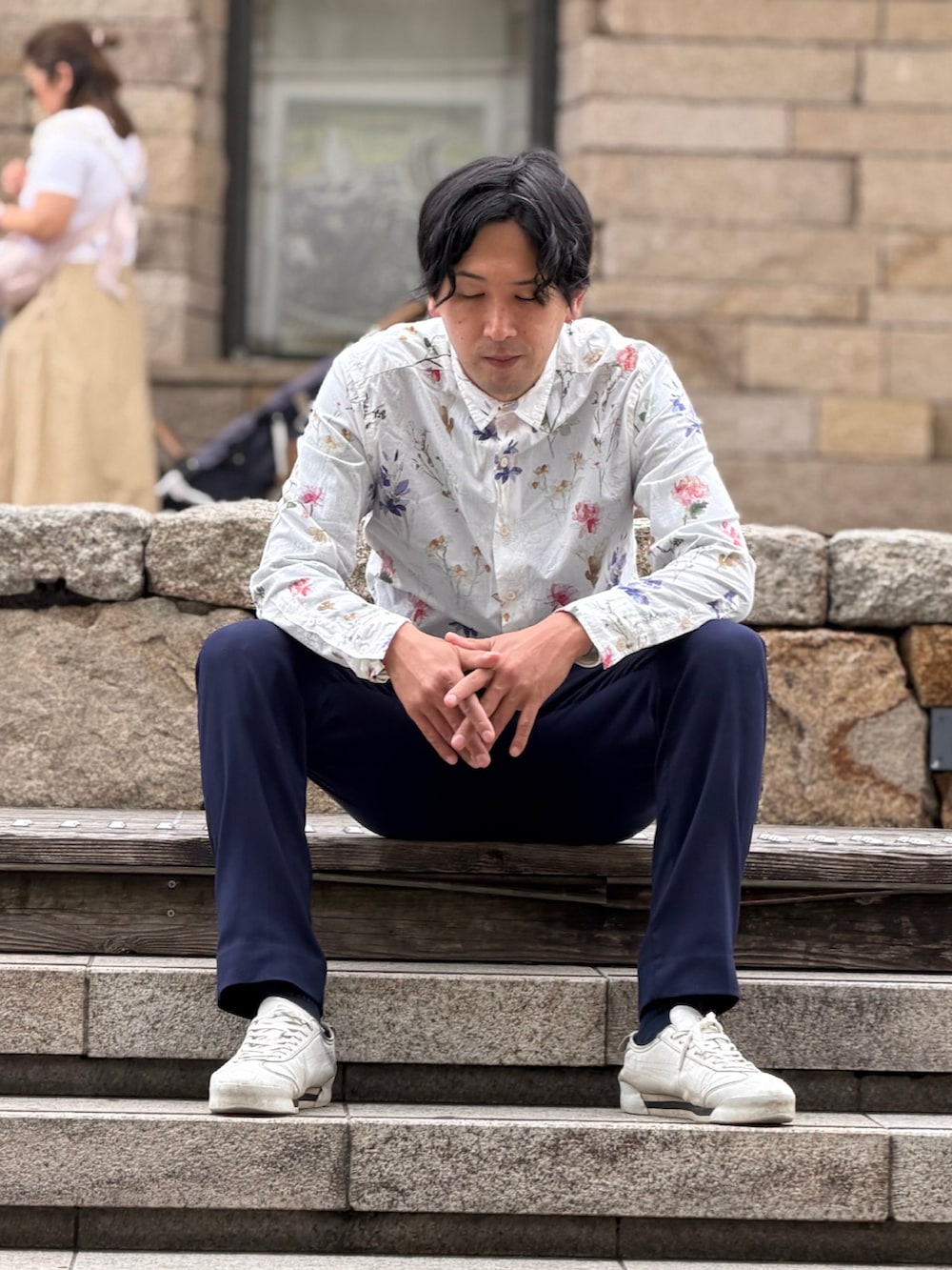 ブルー系のスラックス、ホワイト系のスニーカーを着用したメンズの春コーディネートの2枚目の写真