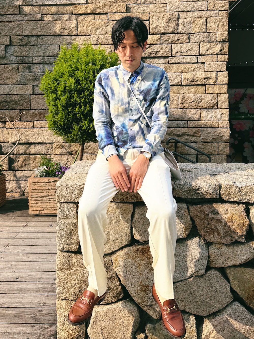 ブルー系のシャツ/ブラウス、ホワイト系のスラックス、シルバー系のイヤリングを着用したメンズの春コーディネートの3枚目の写真