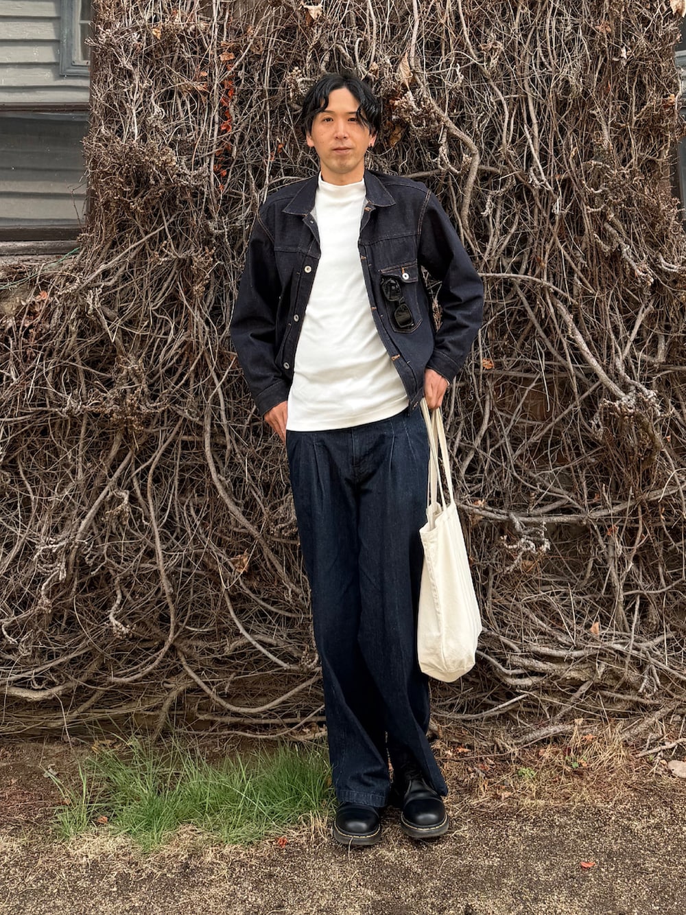 ブルー系のデニムジャケット、ブルー系のデニムパンツ、ベージュ系のトートバッグを着用したメンズの春コーディネートの2枚目の写真