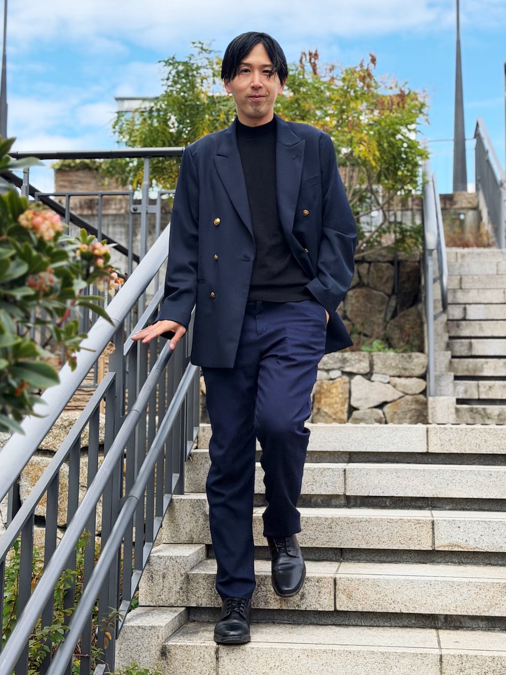 ブルー系のテーラードジャケット、ブルー系のスラックス、ブラック系のドレスシューズを着用したメンズの冬コーディネートの3枚目の写真