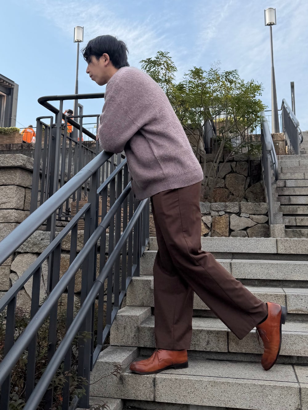 グレー系のニット/セーター、ピンク系のカーディガン/ボレロ、ブラウン系のスラックスを着用したメンズの冬コーディネートの2枚目の写真