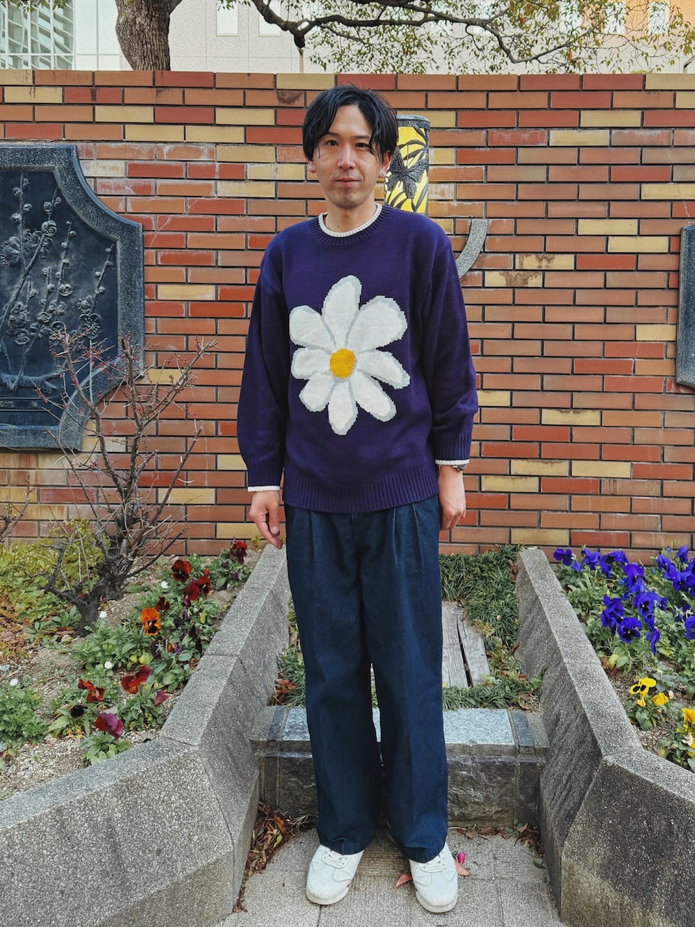 ブルー系のニット/セーター、ブルー系のデニムパンツ、ホワイト系のスニーカーを着用したメンズの冬コーディネートの2枚目の写真