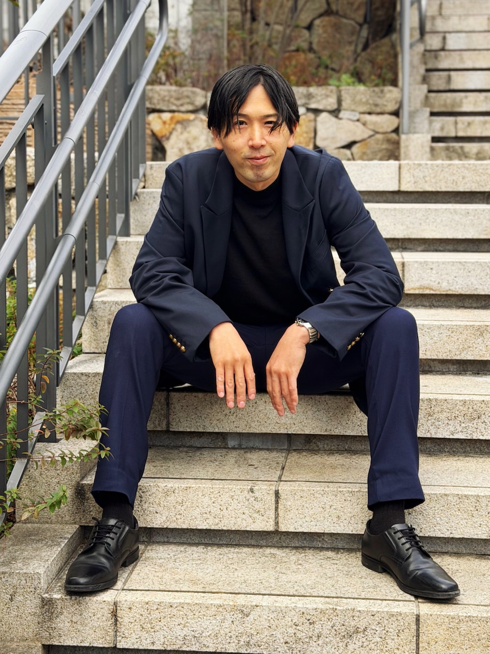 ブルー系のテーラードジャケット、ブルー系のスラックス、ブラック系のドレスシューズを着用したメンズの冬コーディネートの2枚目の写真