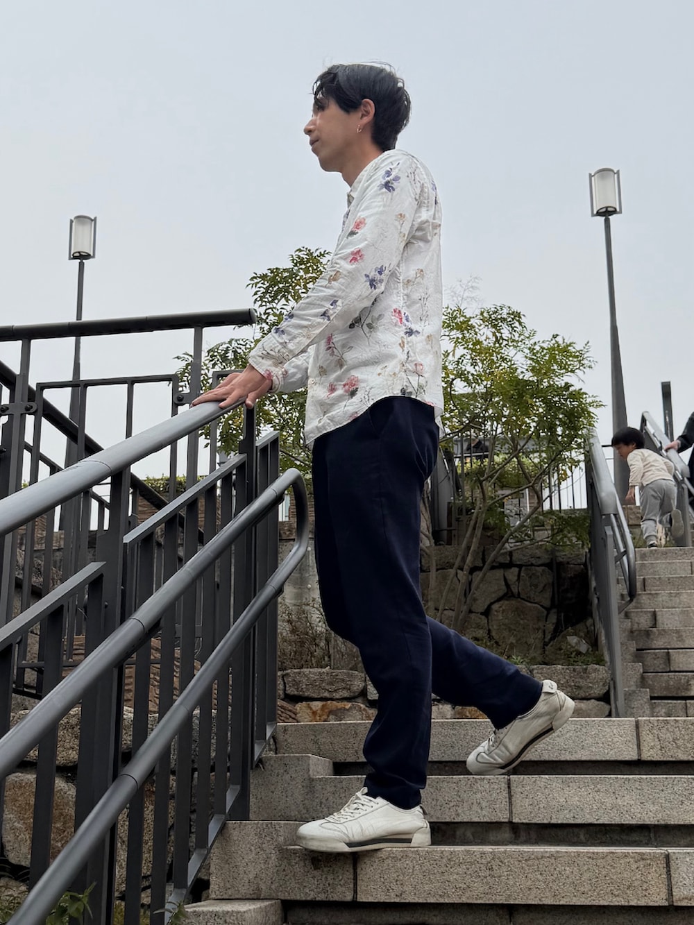 ブルー系のスラックス、ホワイト系のスニーカーを着用したメンズの春コーディネートの3枚目の写真