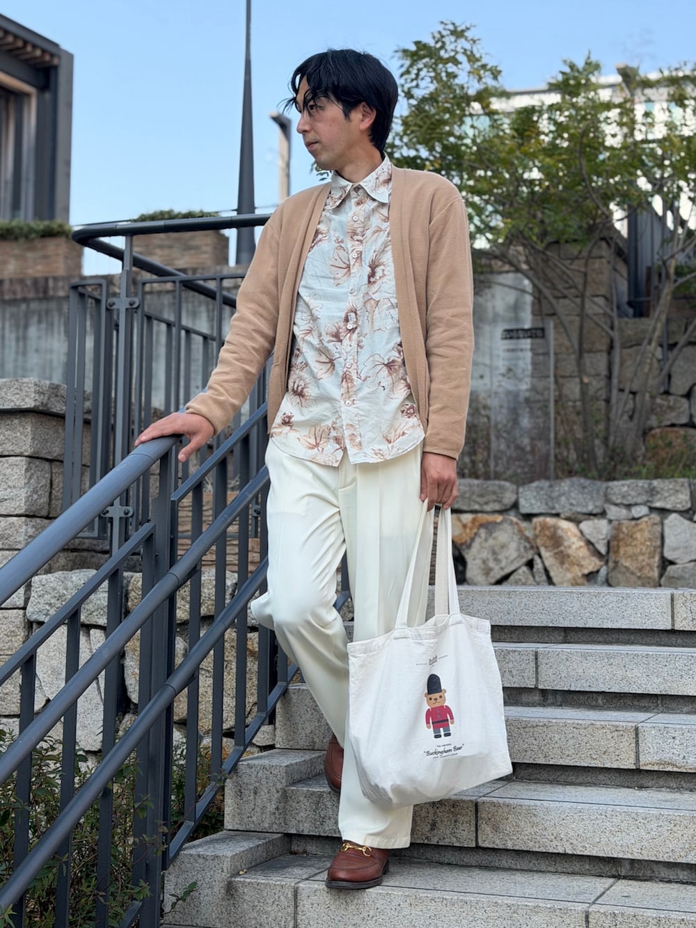 ホワイト系のスラックス、ベージュ系のトートバッグを着用したメンズの春コーディネートの2枚目の写真