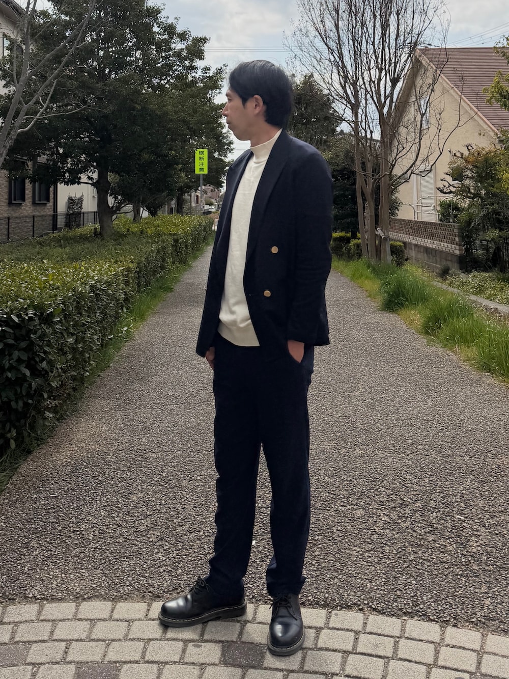 ブルー系のテーラードジャケット、ホワイト系のニット/セーター、ブルー系のスラックスを着用したメンズの春コーディネートの3枚目の写真