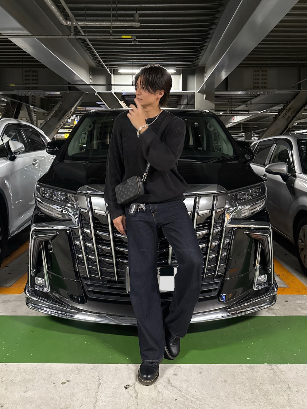 ブラック系のニット/セーター、ブルー系のデニムパンツ、ブラック系のドレスシューズを着用したメンズの秋コーディネートの2枚目の写真