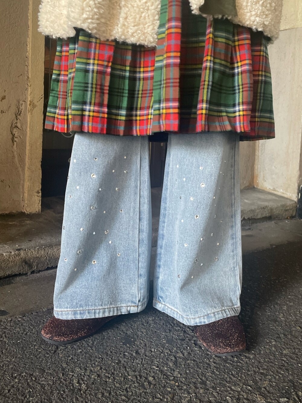 ホワイト系のダッフルコート、グリーン系のハンドバッグ、ブルー系のデニムパンツを着用したレディースの冬コーディネートの5枚目の写真