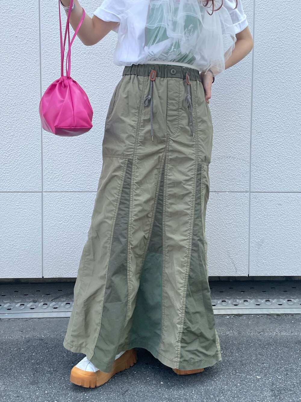 ピンク系のショルダーバッグ、グリーン系のスカート、ホワイト系のその他トップスを着用したレディースの夏コーディネートの5枚目の写真