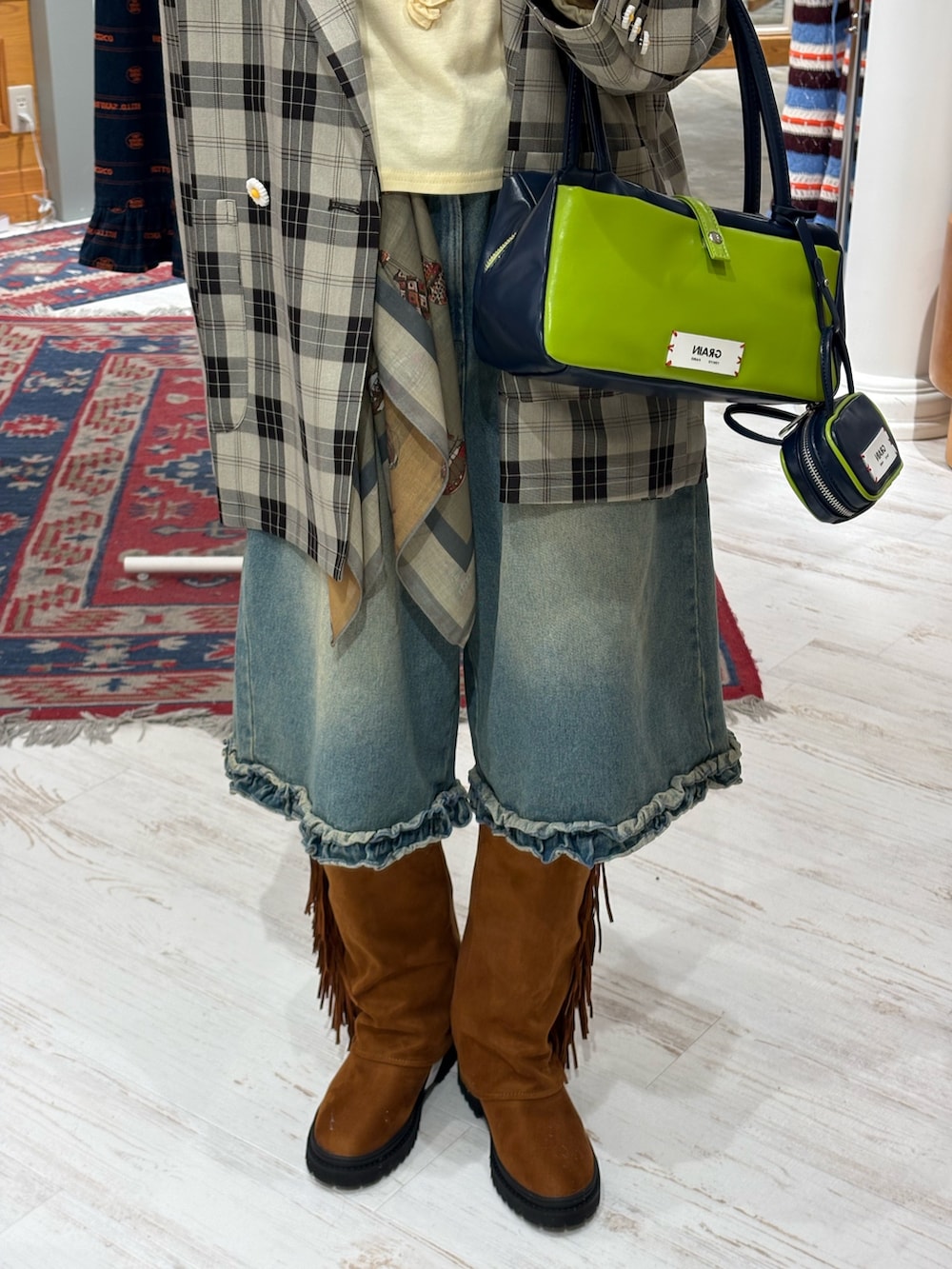 ブラック系のテーラードジャケット、イエロー系のTシャツ/カットソー、ブルー系のデニムパンツを着用したレディースの春コーディネートの2枚目の写真