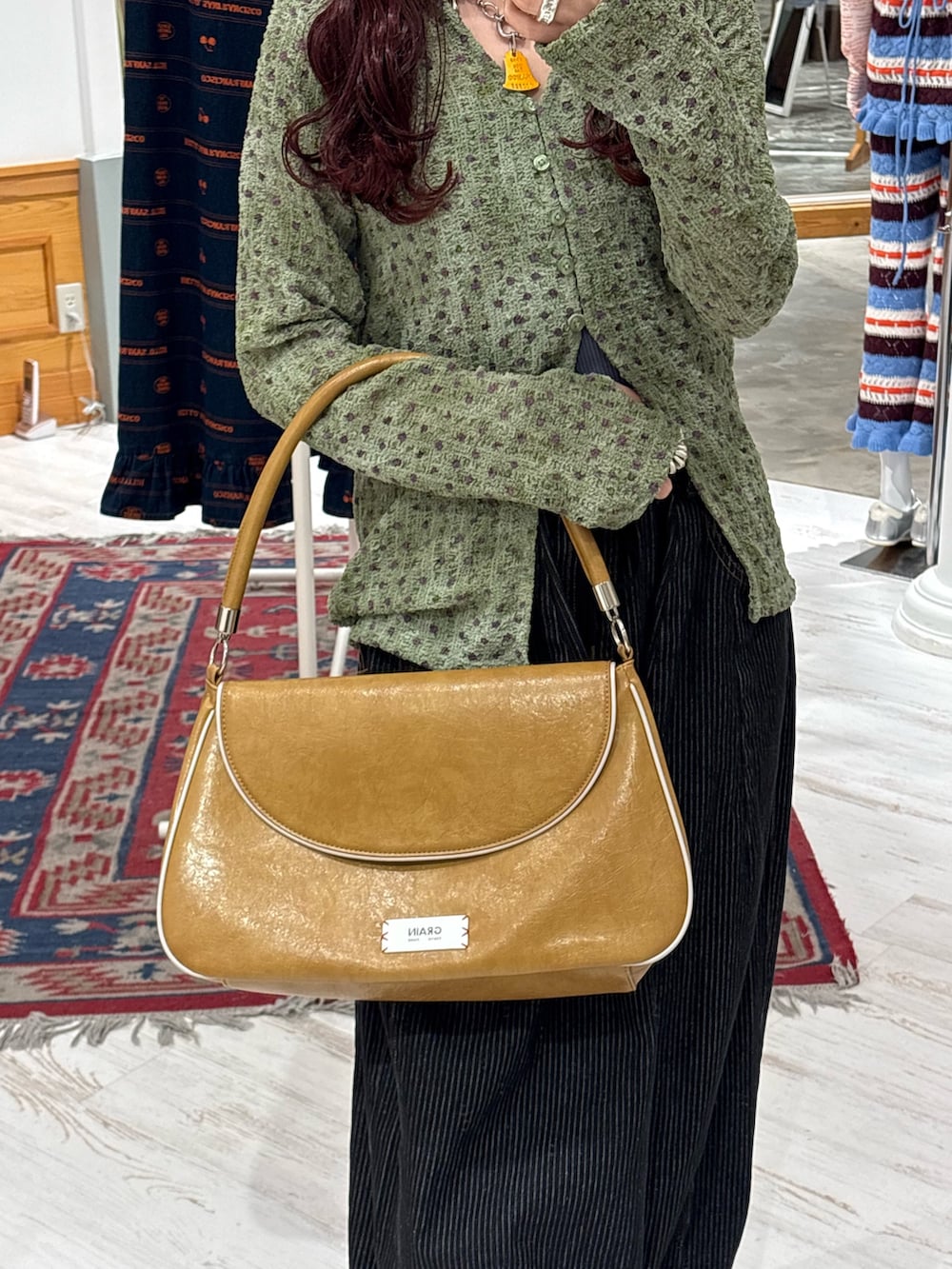 イエロー系のトートバッグ、グリーン系のシャツ/ブラウス、グレー系のデニムパンツを着用したレディースの春コーディネートの3枚目の写真