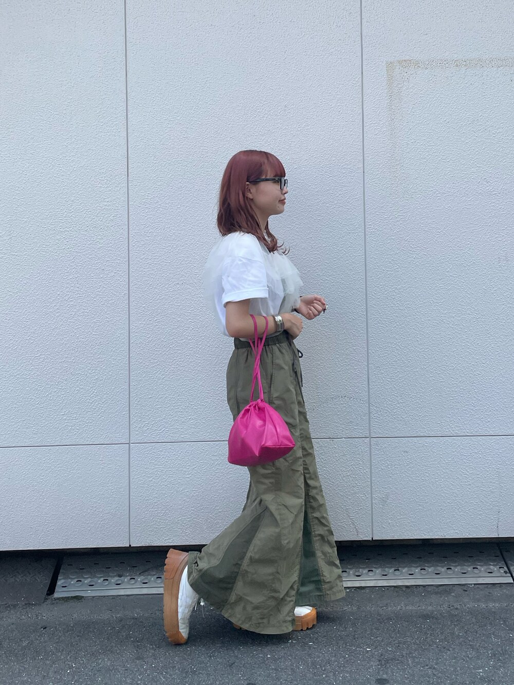 ピンク系のショルダーバッグ、グリーン系のスカート、ホワイト系のその他トップスを着用したレディースの夏コーディネートの2枚目の写真