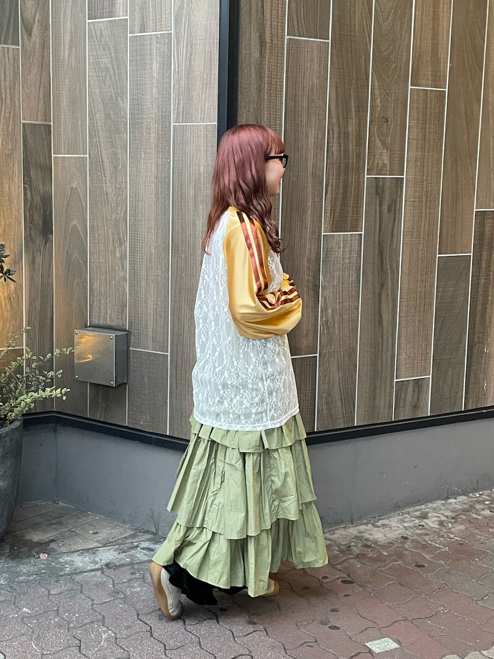 グリーン系のスカート、イエロー系のTシャツ/カットソーを着用したレディースの冬コーディネートの2枚目の写真