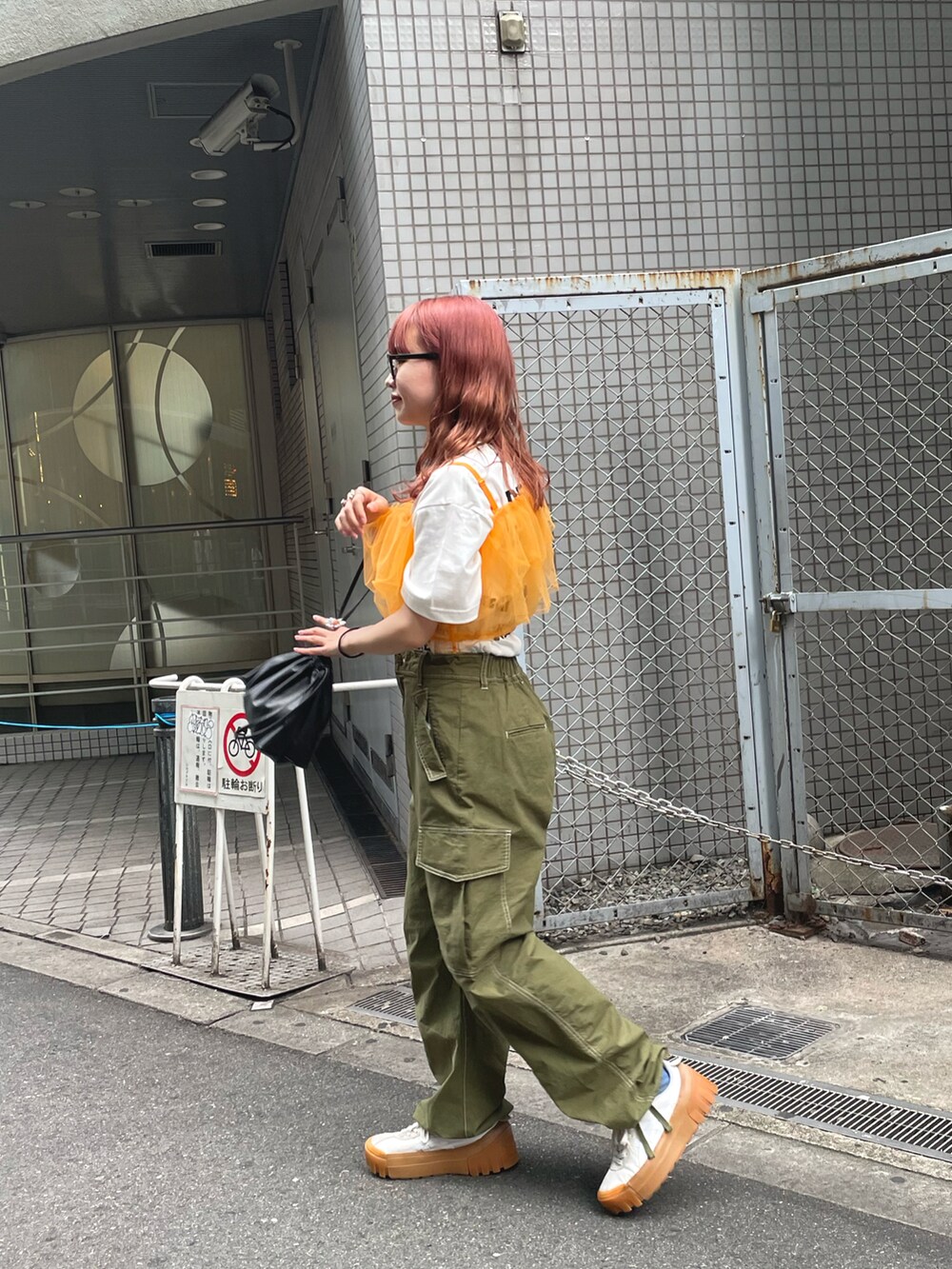 「夏コーデ、Tシャツ、白Tシャツ、オレンジ、オレンジコーデ、カラーコーデ、チュール、ビスチェ、カーゴパンツ、カーキ、巾着バッグ、ディズニーコーデ、レイヤードスタイル」|「CIAOPANICのワンショルダーチュールビスチェ(その他トップス、オレンジ系)」を使った、丸尾佳奈さん(レディース・158cm)の夏コーディネートの2枚目の写真