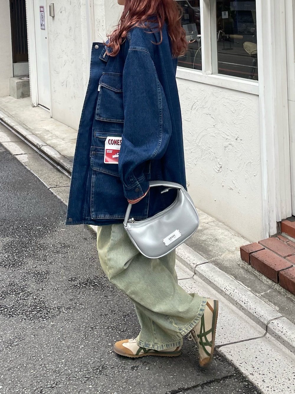 ブルー系のカバーオール、レッド系のTシャツ/カットソー、ホワイト系のキャミソールを着用したレディースの春コーディネートの2枚目の写真